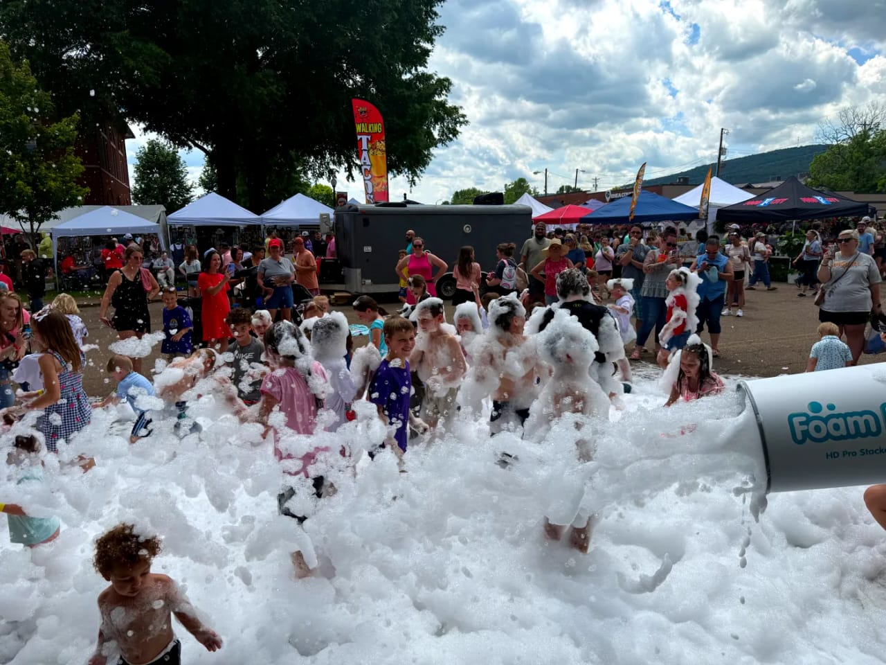 Elite Foam Experiences cannon blasting foam over a cheering crowd of kids