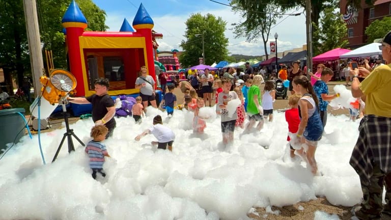Foam cannon and fan filling a community event with foam