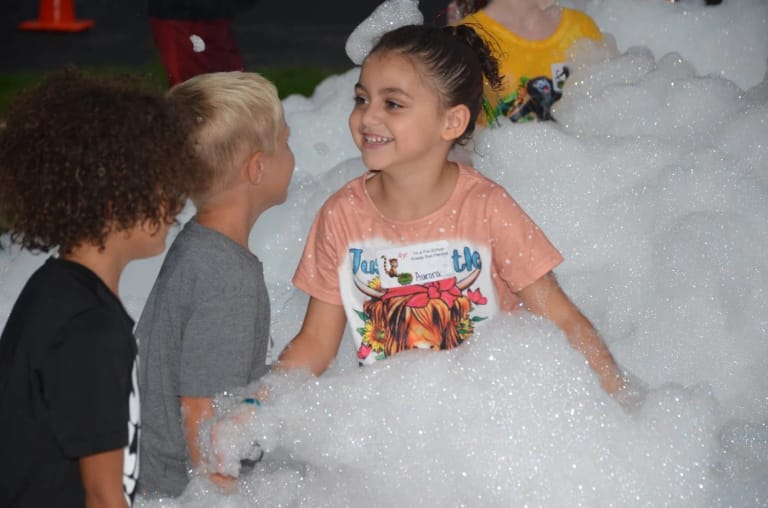 Smiling kids piled into the foam at an Elite Foam Experiences party